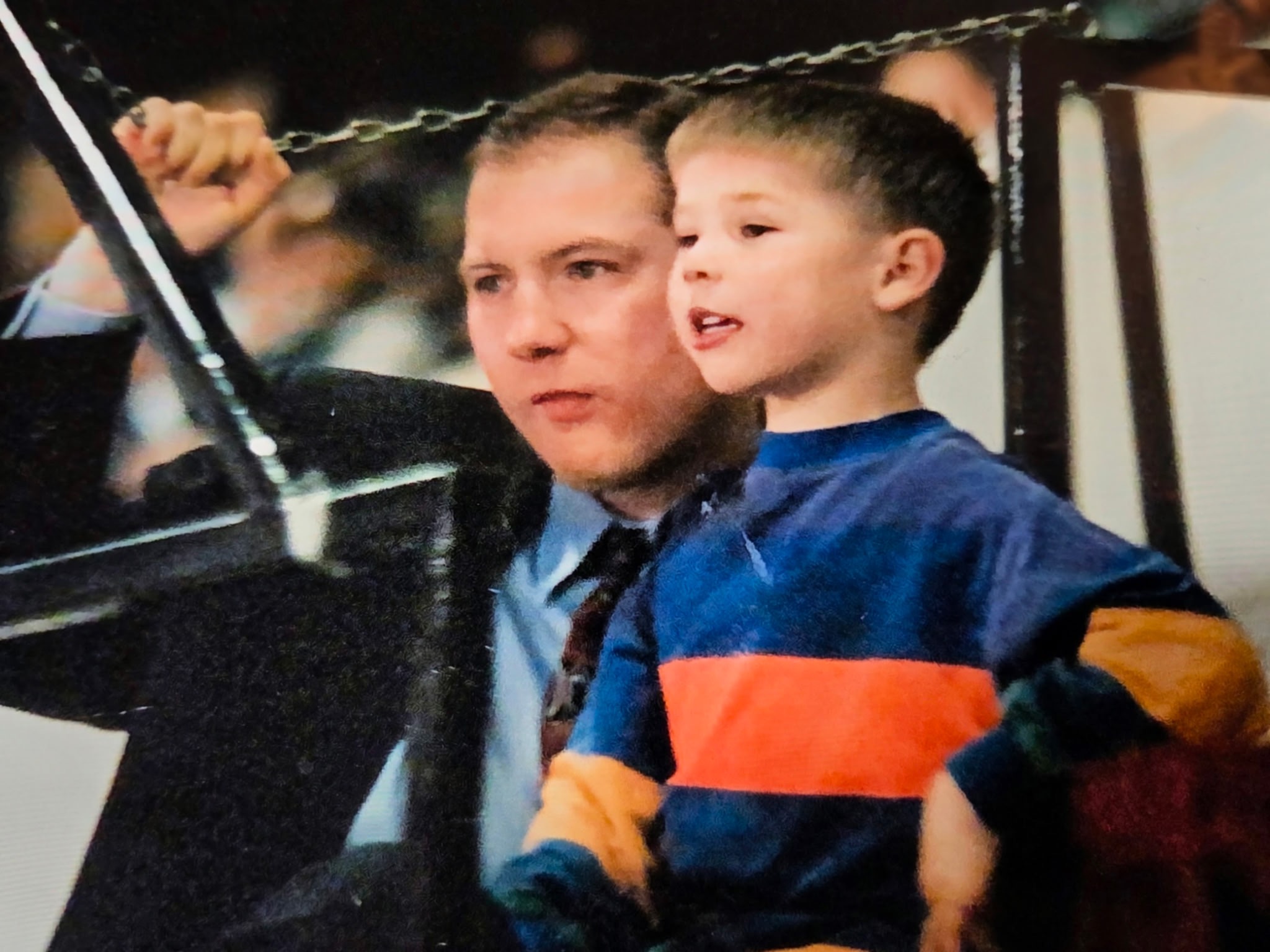 Eric holding Justin on a swing set, an early father-son moment