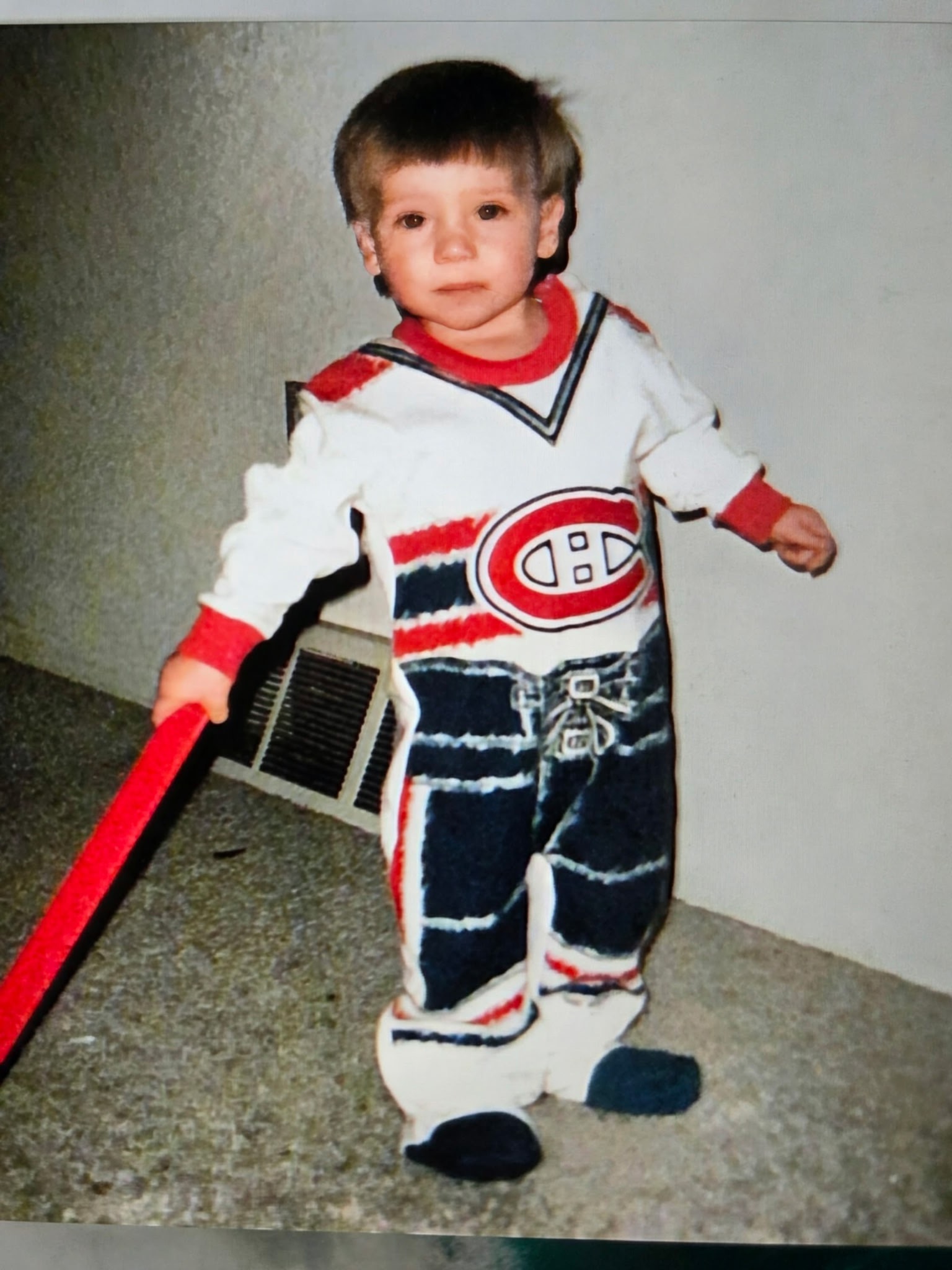 Justin as a toddler in a Montreal Canadiens jersey holding a hockey stick