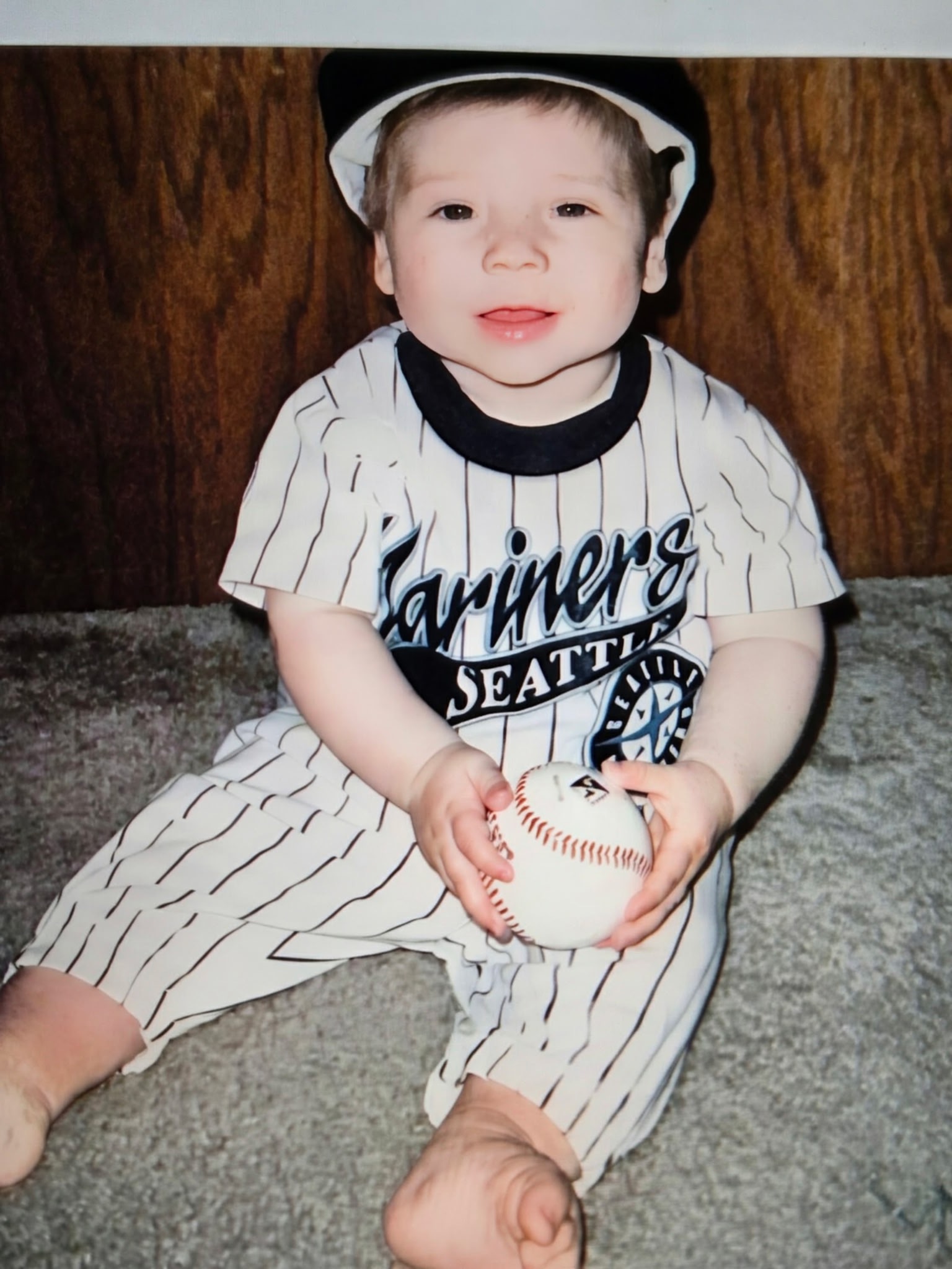 Justin as a baby in a Seattle Mariners onesie